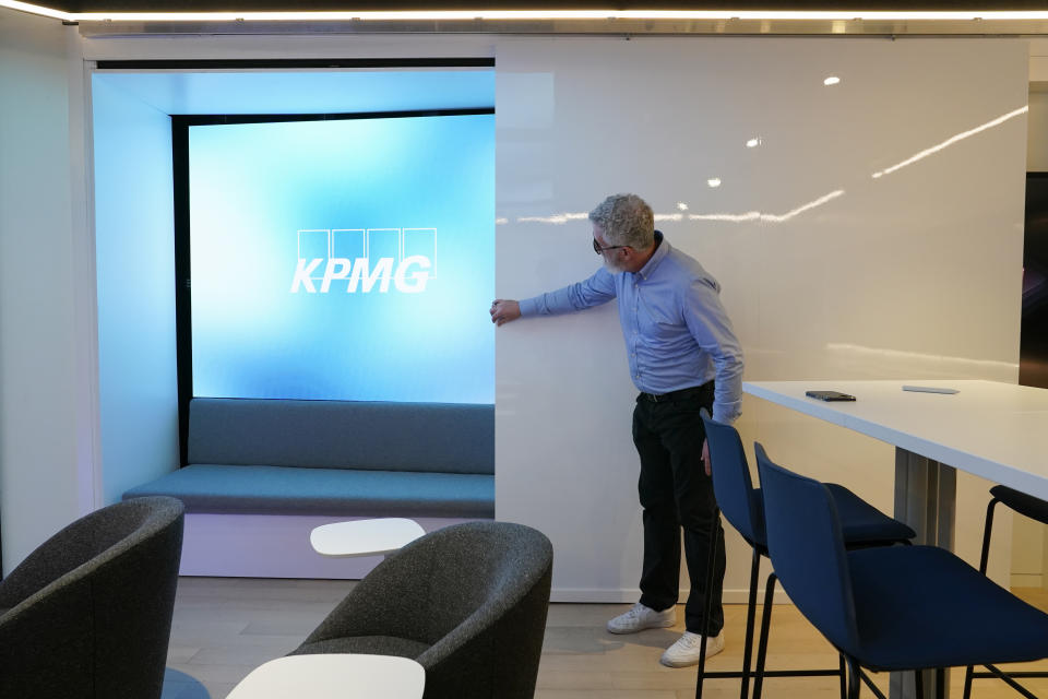 John Hair, director of Insights Centers at KPMG, opens a sliding door to reveal a seating area in a new business suite at Capital One Arena, home to NHL's Washington Capitals and NBA's Washington Wizards, Tuesday, June 7, 2022, in Washington. (AP Photo/Patrick Semansky)