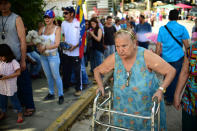 <p>A woman with a walker heads to a polling station as others queue in Caracas on July 16, 2017 during an opposition-organized vote to measure public support for President Nicolas Maduro’s plan to rewrite the constitution. (Ronaldo Schemidt/AFP/Getty Images) </p>