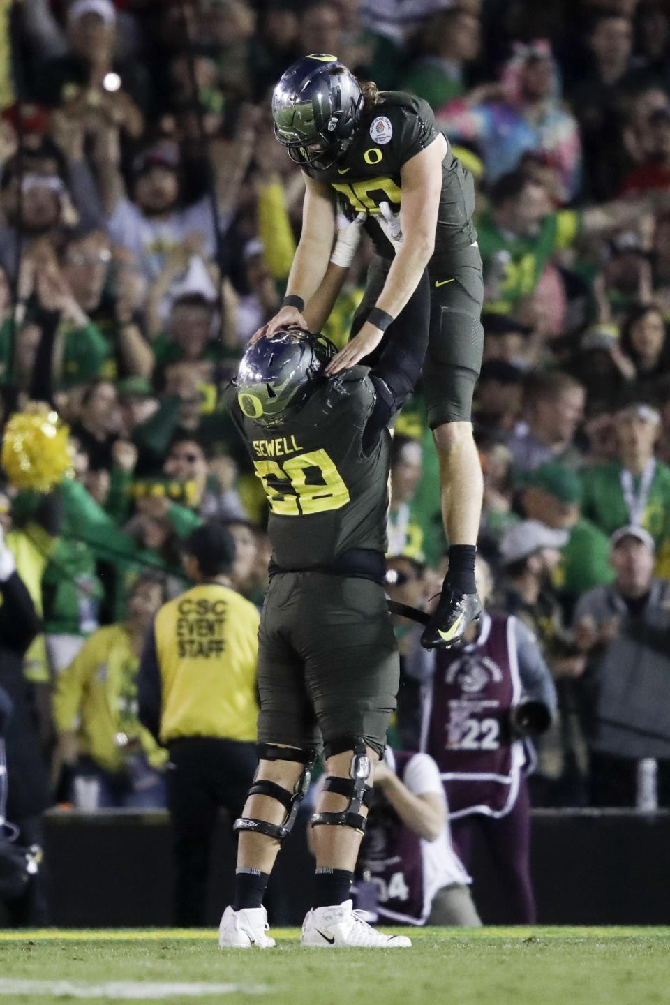 Oregon quarterback Justin Herbert celebrates after scoring with offensive lineman Penei Sewell during second half of the Rose Bowl NCAA college football game against Wisconsin Wednesday, Jan. 1, 2020, in Pasadena, Calif. (AP Photo/Marcio Jose Sanchez)
