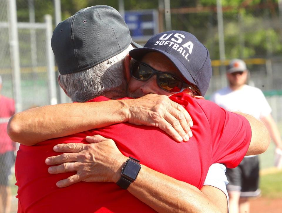 Ralph "Froggy" Poole hugs fellow long-time Bedford Parks Department softball umpire Michelle Riester during his retirement ceremony Monday night.