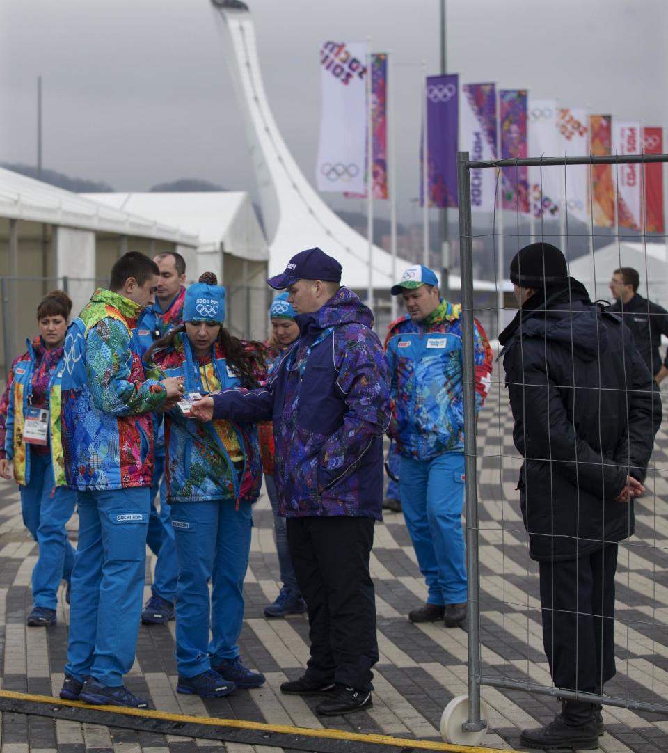 Security personnel check Olympic volunteers' credentials before entering the Olympic Park ahead the 2014 Winter Olympics, Wednesday, Jan. 29, 2014, in Sochi, Russia. (AP Photo/Pavel Golovkin)