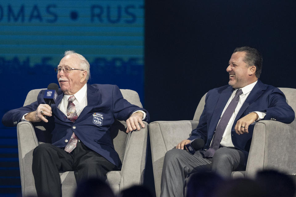 NASCAR Hall of Fame inductee Red Farmer, left, and Tony Stewart laugh prior to the induction ceremony Friday, Jan. 21, 2022, in Charlotte, N.C. (AP Photo/Matt Kelley)