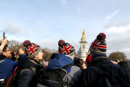 FILE PHOTO: Tourists take pictures outside Buckingham Palace after Prince Harry announced his engagement to Meghan Markle, in London, Britain, November 27, 2017. REUTERS/Darrin Zammit Lupi/File Photo