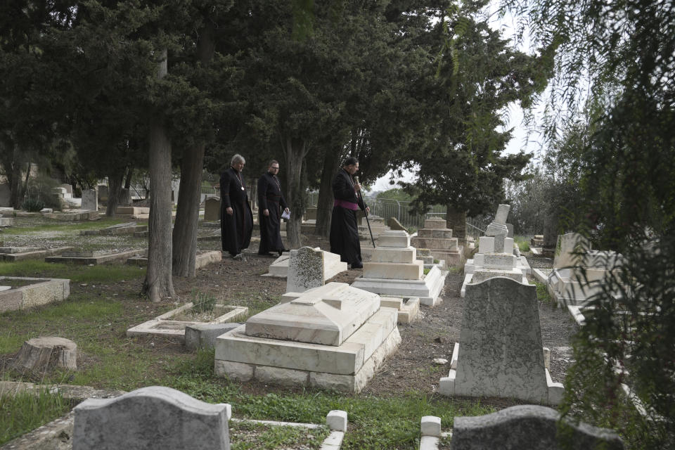 Hosam Naoum, a Palestinian Anglican bishop, walks with other clergy where vandals desecrated more than 30 graves at a historic Protestant Cemetery on Jerusalem's Mount Zion in Jerusalem, Wednesday, Jan. 4, 2023. Israel's foreign ministry called the attack an "immoral act" and "an affront to religion." Police officers were sent to investigate the profanation. (AP Photo/ Mahmoud Illean)