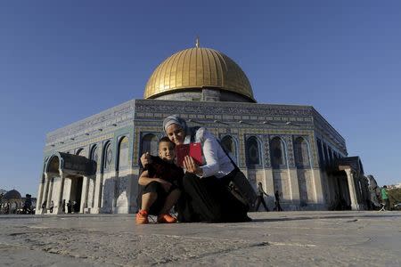 Palestinian Nura Darawshe, 40, from the West Bank village of Turmus Aya near Nablus, takes a selfie photo with her son in front of the Dome of the Rock on the compound known to Muslims as Noble Sanctuary and to Jews as Temple Mount, in Jerusalem's Old City, during the holy month of Ramadan, July 4, 2015. REUTERS/Ammar Awad