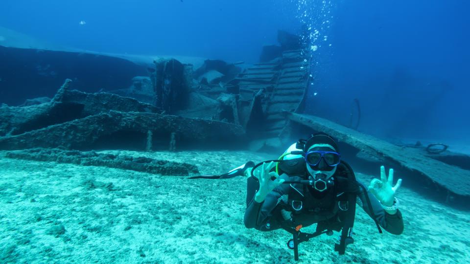 A scuba divers signals they are OK during a wreck dive.