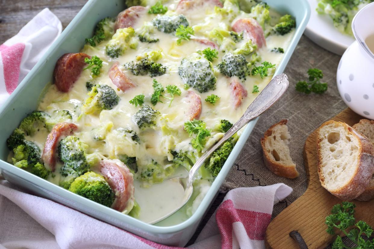 Broccoli gratin with bechamel sauce and sausages in ceramic bakeware