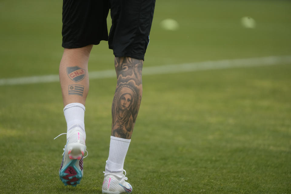 Napoli's Mathias Olivera, sports a tattoo of the Virgin Mary on his right leg calf as he walks on the pitch during a training session at the club headquarters in Castel Volturno, near Naples, Wednesday, April 5, 2023. Unlike other major cities in Italy, Naples has only one major soccer team and the fan support for Napoli is felt on every street and alleyway. Lobotka, who developed with Ajax’s junior squad and then played for Danish club Nordsjaelland and Spanish side Celta Vigo before transferring to Italy, had never experienced anything like Napoli. (AP Photo/Gregorio Borgia)