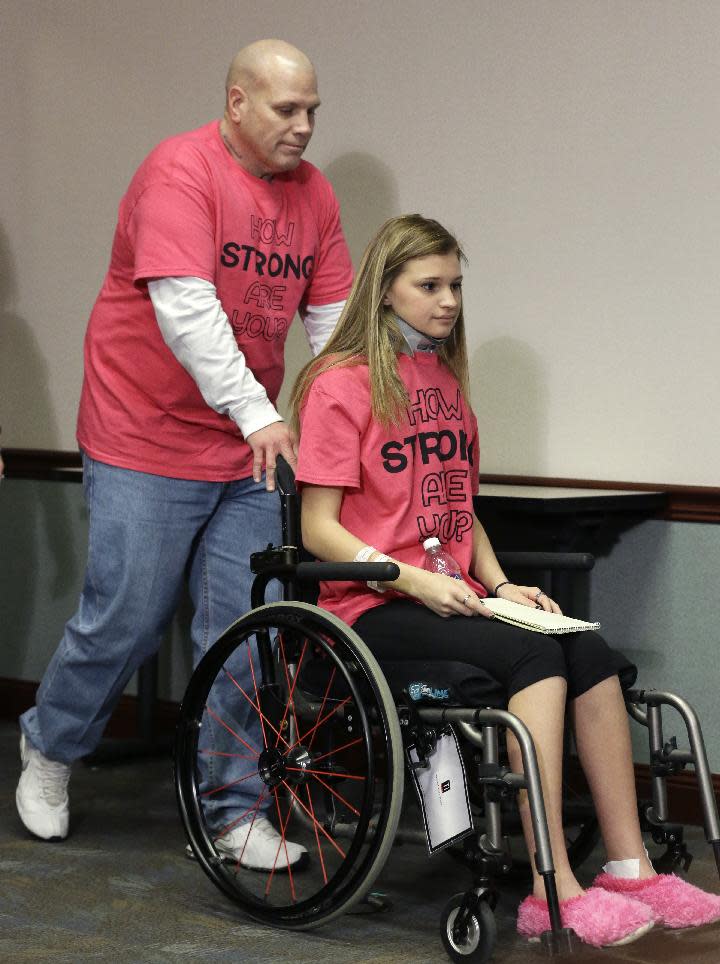 Makenzie Wethington is pushed in a wheelchair by her father Joe Wethington before a news conference at Baylor University Medical Center Thursday, Feb. 13, 2014, in Dallas. Wethington spoke for the first time publicly since she survived a fall of more than 3,000 feet in a Jan. 25, 2014 skydiving accident in Oklahoma. Her doctor has said she's walking with assistance and is expected to recover. Her injuries included damage to her liver and a broken pelvis, lumbar spine in her lower back, shoulder blade, several ribs and teeth. (AP Photo/LM Otero)