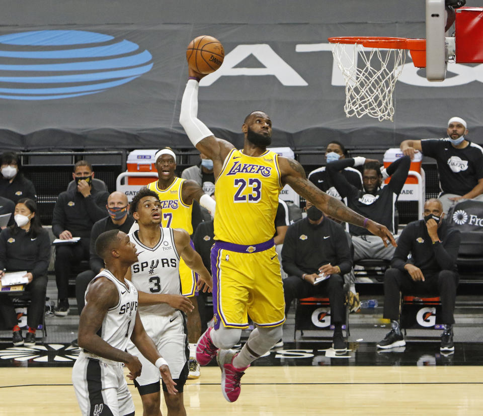 SAN ANTONIO, TX - DECEMBER 30  LeBron James #23 of the Los Angeles Lakers dunks past spurs defenders during first half action at AT&T Center on December   30, 2020 in San Antonio, Texas.  NOTE TO USER: User expressly acknowledges and agrees that , by downloading and or using this photograph, User is consenting to the terms and conditions of the Getty Images License Agreement. (Photo by Ronald Cortes/Getty Images)