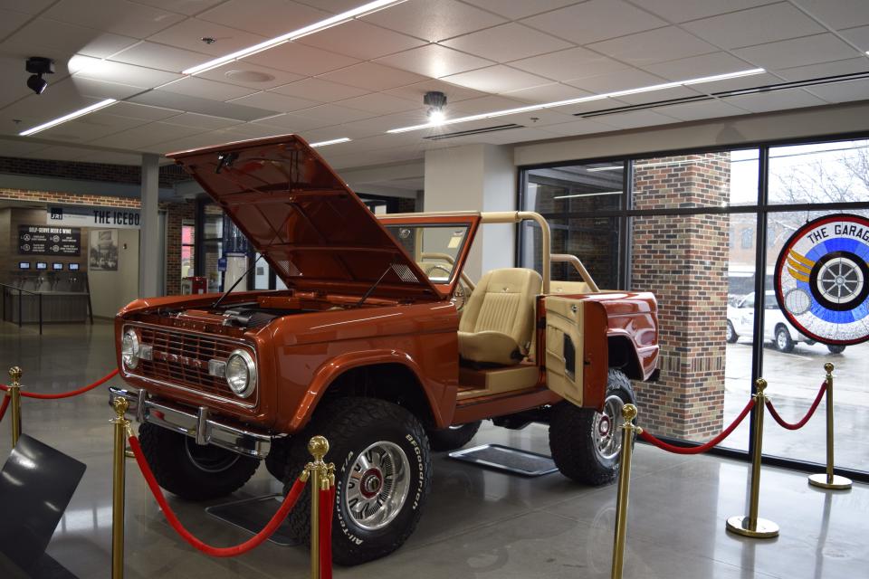 A 1974 Ford Bronco that has been restored and modified with a modern Coyote V8 engine, suicide doors and other changes. The car greets guests before they walk into the rest of the Going Tops Down exhibit at The Garage.