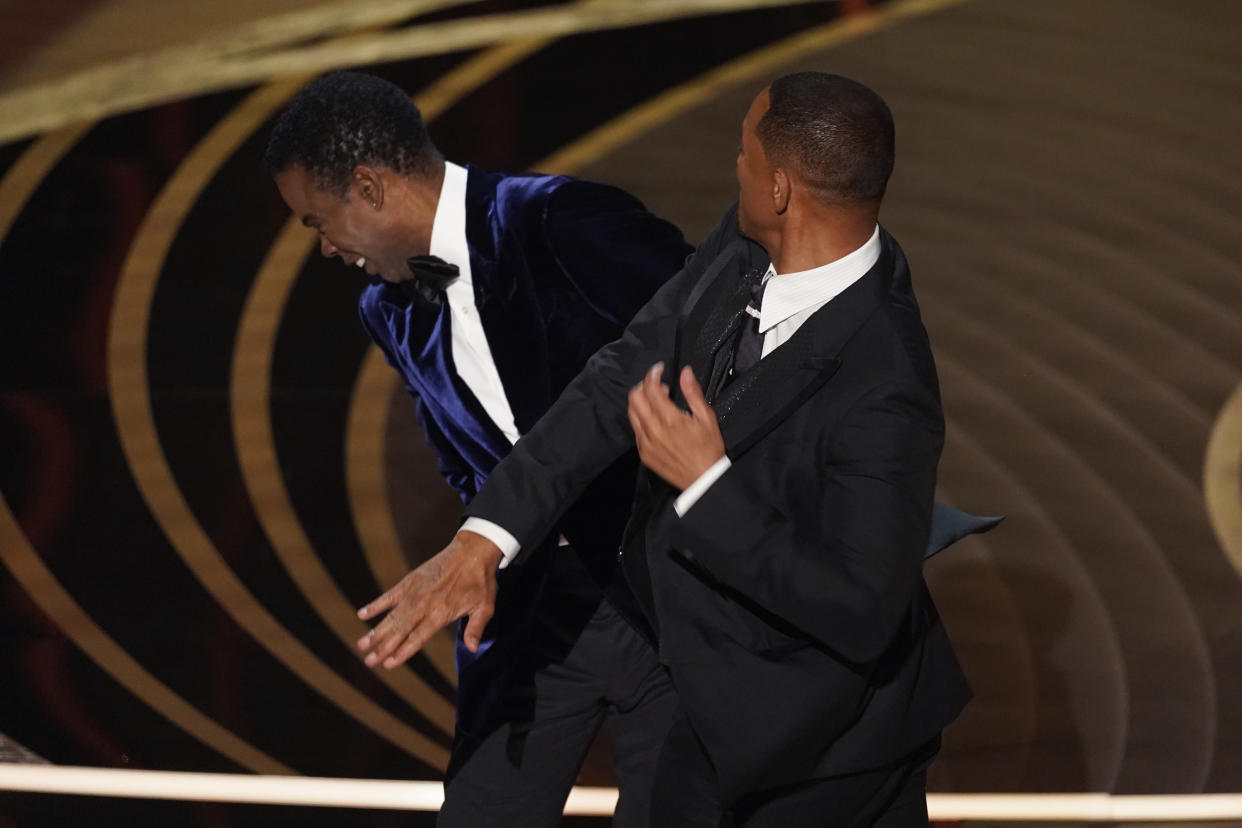 FILE - Will Smith, right, hits presenter Chris Rock on stage at the Oscars in Los Angeles on March 27, 2022, after Rock made a joke about his wife. Pinkett Smith turned her husband’s Oscar-night blowup into a teachable moment on “Red Table Talk,” her Facebook Watch show on June 1. (AP Photo/Chris Pizzello, File)