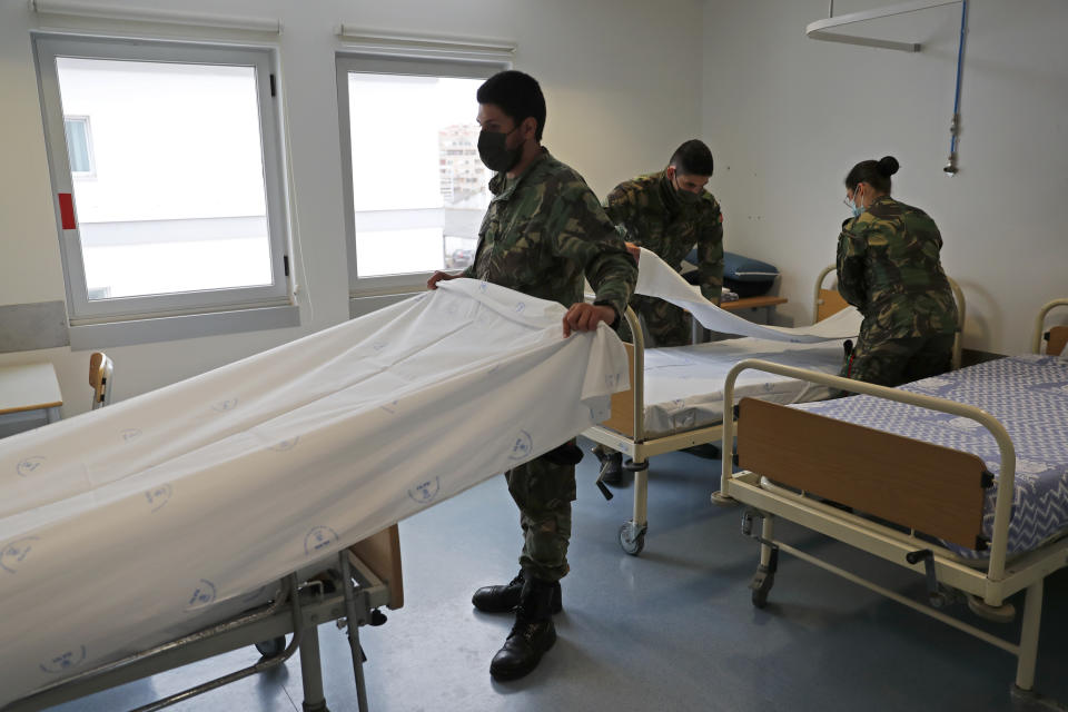 Soldiers prepare beds in a new COVID-19 ward being set up at the Military Hospital in Lisbon, Tuesday, Jan. 26, 2021. The military hospital is expanding it's number of beds available to take COVID-19 patients from the National Health Service. Portugal is reporting new daily records of COVID-19 deaths and hospitalizations as a recent pandemic surge continues unabated. (AP Photo/Armando Franca)