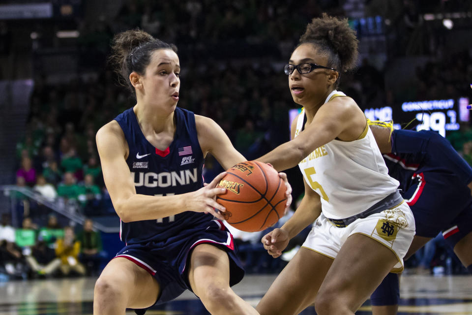 Notre Dame's Olivia Miles, right, defends Connecticut's Lou Lopez Sénéchal (11) during the second half of an NCAA college basketball game on Sunday, Dec. 4, 2022, in South Bend, Ind. (AP Photo/Michael Caterina)