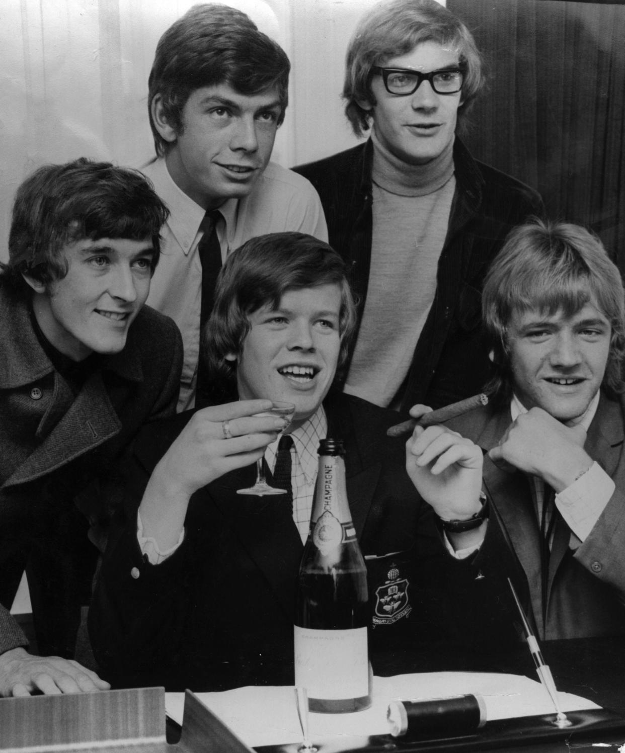 Herman's Hermits, shown in 1966 with singer Peter Noone (center) enjoying a glass of champagne and a cigar.