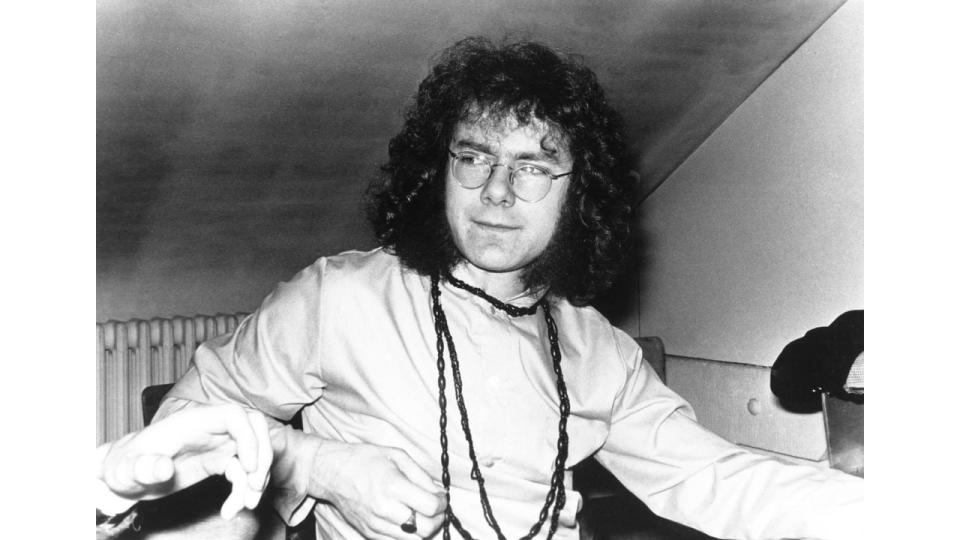 Black and white photo of Robert Fripp with long curly hair