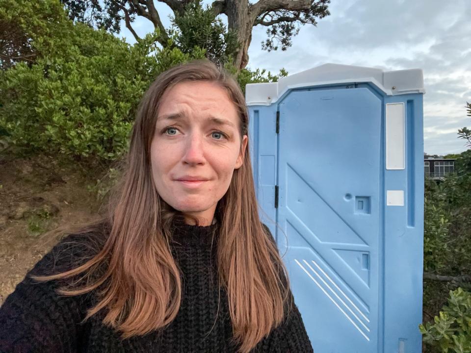 The author in front of the porta-potty.