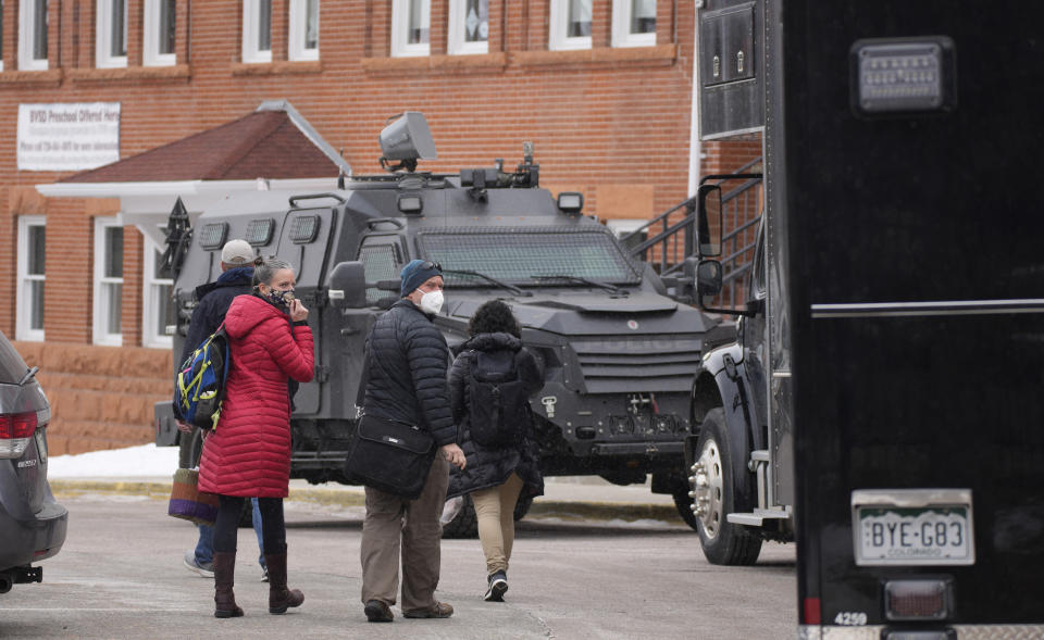 Police vehicles sit in front of University Hill Elementary School across from the campus of the University of Colorado after a man accused of making mass shooting threats against the college as well as the University of California, Los Angeles, was arrested Tuesday, Feb. 1, 2022, in Boulder, Colo. The police operation caused the evacuation of the elementary school and shelter-in-place orders for nearby residents on Boulder's University Hill. (AP Photo/David Zalubowski)