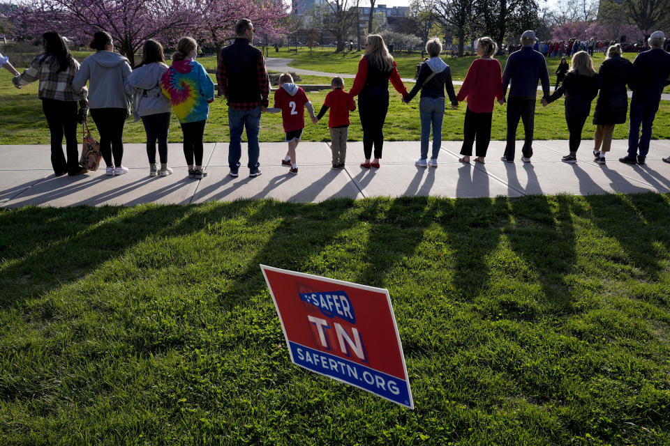 People hold hands and link arms during the Linking Arms for Change human chain Wednesday, March 27, 2024, in Nashville, Tenn. The event was to commemorate the one-year anniversary of the Covenant School mass shooting. (AP Photo/George Walker IV)