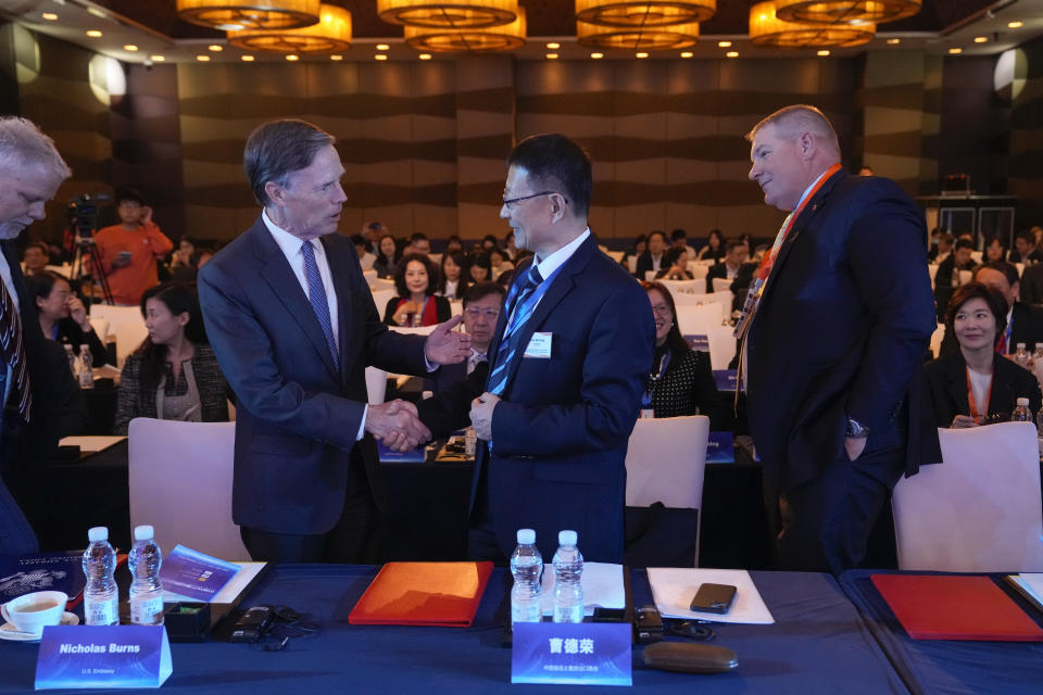 U.S. Ambassador to China Nicholas Burns, second left, shakes hands with Cat Derong, president of China Chamber of Commerce of Import and Export of Foodstuffs, Native Products and Animal By-products (CFNA) as they attend the China U.S. agricultural trade cooperation forum in Beijing on Nov. 2, 2023. (AP Photo/Andy Wong)