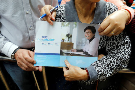 Chief Executive election candidate and former Chief Secretary Carrie Lam's supporters hold an election platform as they wait for Lam during her visit in Hong Kong, China March 23, 2017. REUTERS/Tyrone Siu