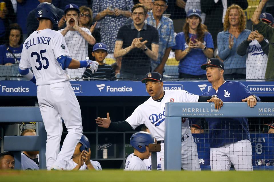 Los Angeles Dodgers' Cody Bellinger, left, is congratulated by manger Dave Roberts, center, and coach Bob Geren after hitting a solo home run during the sixth inning of the team's baseball game against the San Diego Padres on Thursday, July 4, 2019, in Los Angeles. (AP Photo/Mark J. Terrill)