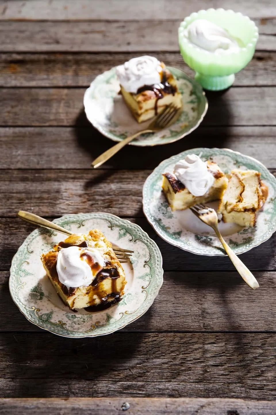 brioche bread pudding with bourbon butterscotch sauce and whipped cream on vintage plates