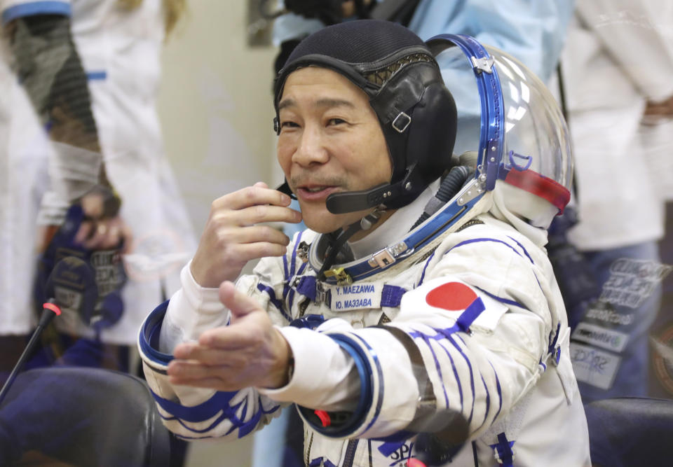 In this photo released by the Roscosmos Space Agency, spaceflight participant Yusaku Maezawa of Japan, member of the main crew of the new Soyuz mission to the International Space Station (ISS) gestures prior to the launch at the Russian leased Baikonur cosmodrome, Kazakhstan, Wednesday, Dec. 8, 2021. (Pavel Kassin, Roscosmos Space Agency via AP)