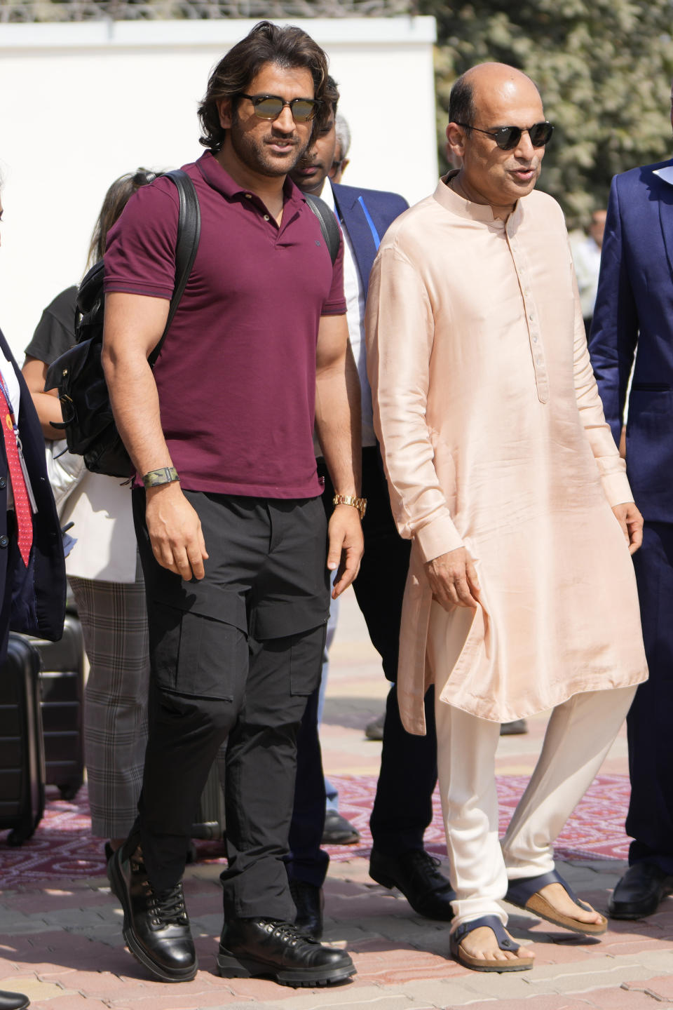 Indian cricketer Mahendra Singh Dhoni, left, arrives to attend a pre-wedding bash of billionaire industrialist Mukesh Ambani's son Anant Ambani, in Jamnagar, India, Friday, March 1, 2024. (AP Photo/Ajit Solanki)