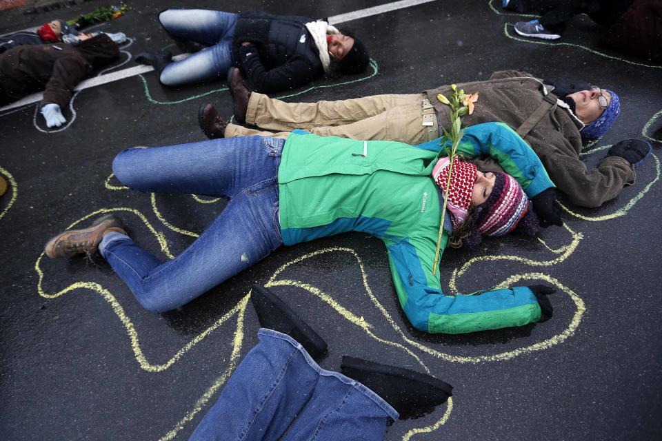 Demonstrators lay on the ground with chalk outlines representing a mock crime scene during a protest marking the 100th day since the shooting death of Michael Brown in St. Louis