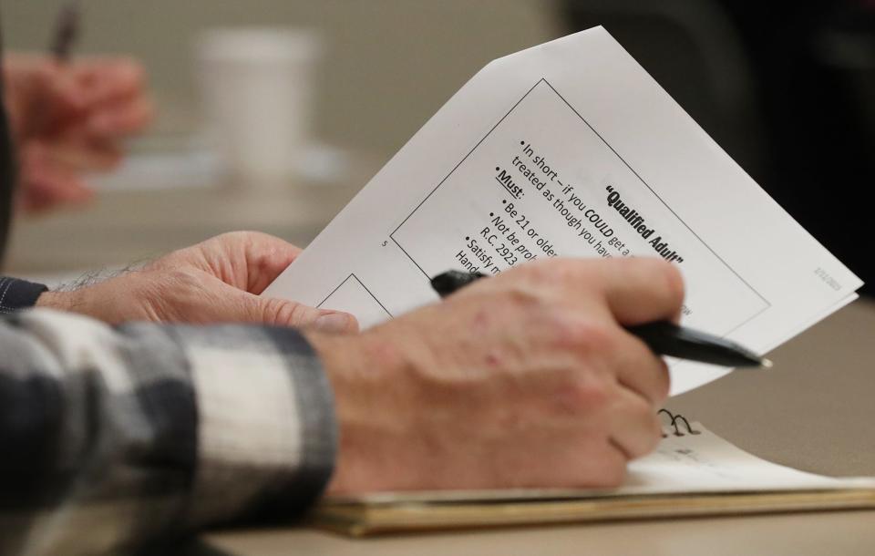 An Atendeed take notes during a concealed carry workshop at the Summit County Sheriff's Office Training Center in Green.