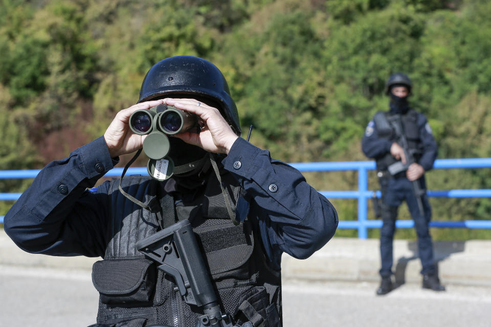 Kosovo police officers patrol the bridge over Gazivode lake near the northern Kosovo border crossing of Brnjak on the fifth day of protest on Friday, Sept. 24, 2021. Ethnic Serbs in Kosovo have been blocking the border for a fifth straight day to protest a decision by Kosovo authorities to start removing Serbian license plates from cars entering the country, raising fears such incidents could unleash much deeper tensions between the two Balkan foes.(AP Photo/Visar Kryeziu)