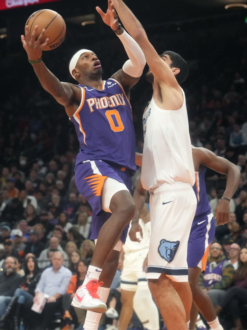 Phoenix Suns forward Torrey Craig (0) lays the ball up while being fouled by Memphis Grizzlies forward Santi Aldama (7) at Footprint Center on Jan. 22, 2023.