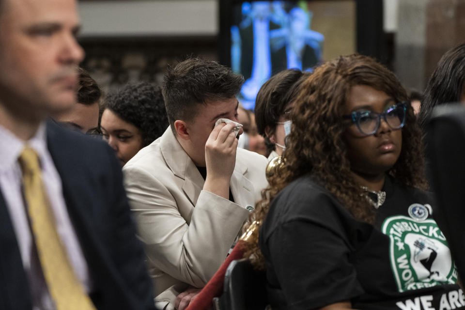 Sam Amato, center, of Buffalo, N.Y., who is a member of the Union and says he was illegally fired from Starbucks after 13 years, becomes emotional during testimony by former Starbucks CEO Howard Schultz, before the Senate Health, Education, Labor and Pensions committee, Wednesday, March 29, 2023, on Capitol Hill in Washington. (AP Photo/Jacquelyn Martin)