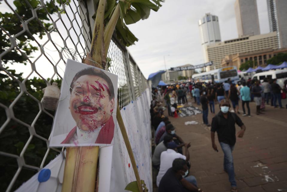 FILE - A vandalised portrait of Prime Minister Mahinda Rajapaksa is seen at an ongoing protest site outside President Gotabaya Rajapaksa's office in Colombo, Sri Lanka, April 23, 2022. With one brother president, another prime minister and three more family members cabinet ministers, it appeared that the Rajapaksa clan had consolidated its grip on power in Sri Lanka after decades in and out of government. With a national debt crisis spiraling out of control, it looks like the dynasty is nearing its end with Mahinda stepping down on Monday, May 9, 2022, and the three Rajapaksas resigning their cabinet posts in April, but the family is not going down without a fight. (AP Photo/Eranga Jayawardena, File)