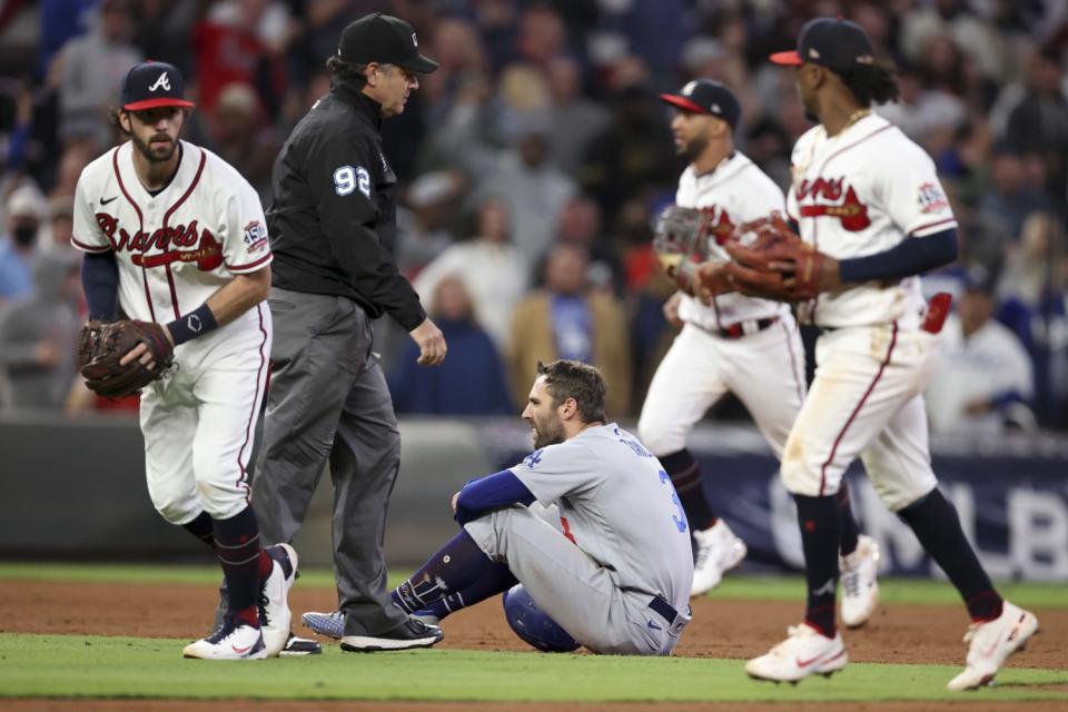 Dodgers' Chris Taylor sits on the field after being caught in a rundown