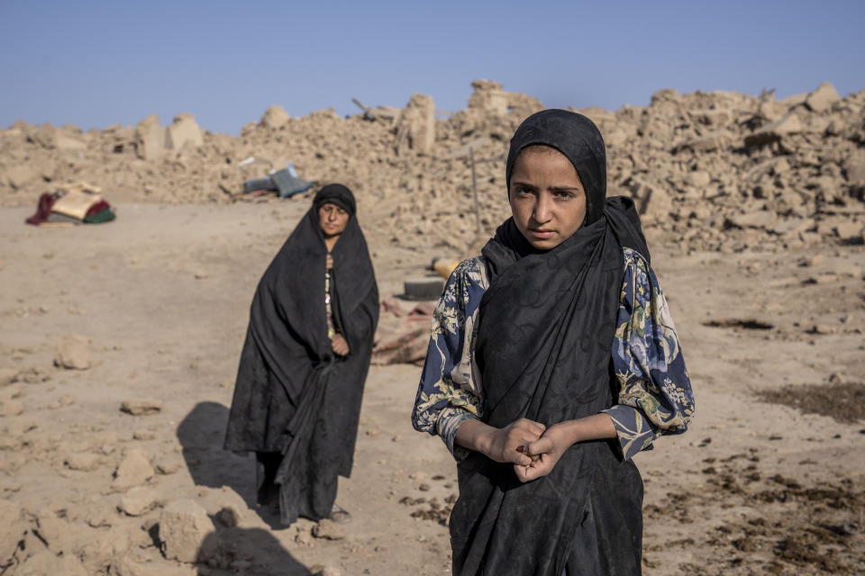 An Afghan girl stands in front of her house that was destroyed by the earthquake in Zenda Jan district in Herat province, western Afghanistan, Wednesday, Oct. 11, 2023. Another strong earthquake shook western Afghanistan on Wednesday morning after an earlier one killed more than 2,000 people and flattened whole villages in Herat province in what was one of the most destructive quakes in the country's recent history. (AP Photo/Ebrahim Noroozi)