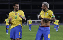 Brazil's Lucas Paqueta, left, celebrates with teammate Neymar after scoring his side's opening goal against Peru during a Copa America semifinal soccer match at Nilton Santos stadium in Rio de Janeiro, Brazil, Monday, July 5, 2021. (AP Photo/Silvia Izquierdo)