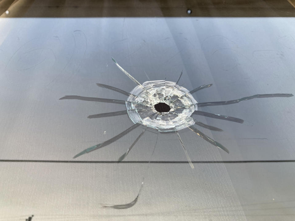 A bullet hole is visible in the glass transom over the door at the Mahogany Masterpiece dance studio in Dadeville, Ala., Sunday, April 16, 2023. Several people were killed and multiple others injured in a shooting at a birthday party at the dance studio the previous night. (AP Photo/Jeff Amy)