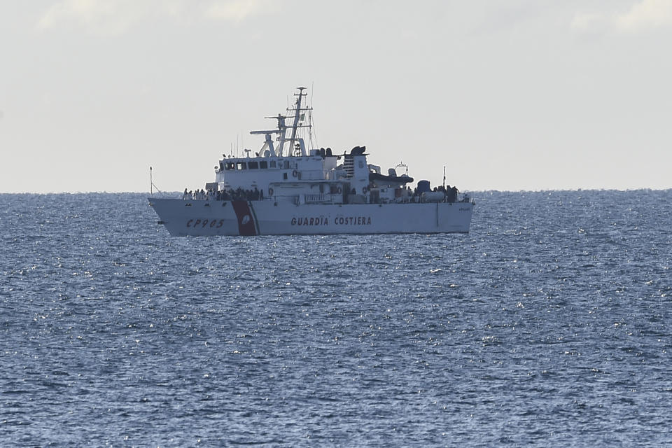 The Italian coast guard ship Peluso approaches the Sicilian harbor of Catania, Italy, Monday, April 17, 2023, with some 300 migrants saved from the sea. (AP Photo/Salvatore Cavalli)