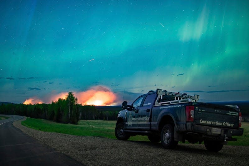 This photo provided by the Ministry of Water, Land and Resource Stewardship shows a wildfire, Aurora Borealis overhead, near Fort Nelson, British Columbia Saturday, May 11, 2024. - Photo: Ministry of Water, Land and Resource Stewardship/The Canadian Press (AP)