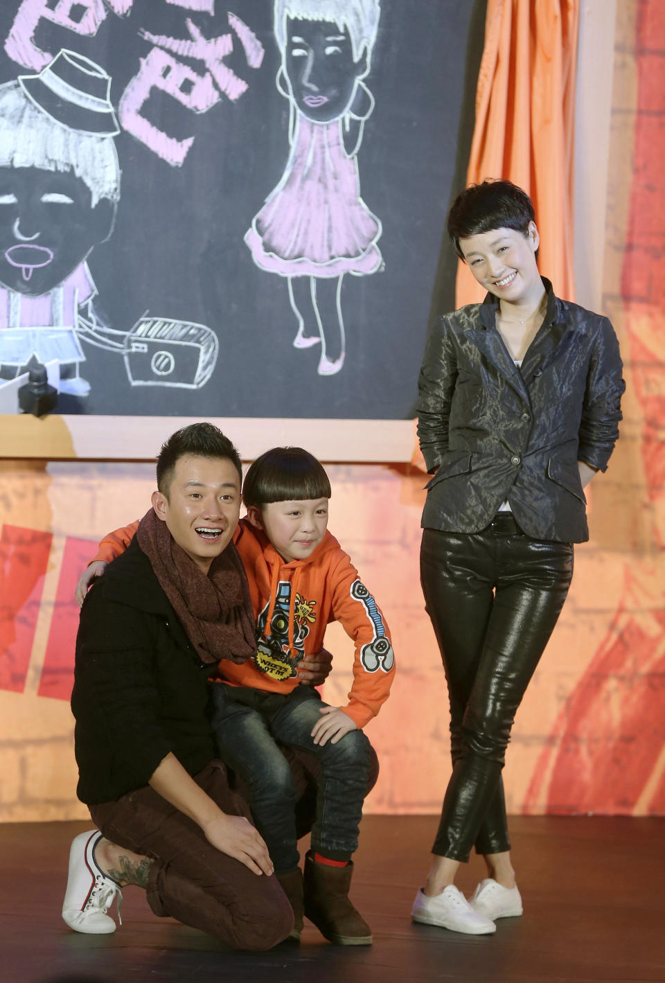 In this Wednesday Dec. 5, 2012 photo, Chinese actor Wen Zhang, left, and his wife Ma Yili, a producer and actress pose with a child actor as they attend a presser for their TV series "Little Daddy" in Beijing, China. The Chinese actor's apology to his actress wife following rumors of his infidelity has set a record for comments and retweets on China's version of Twitter. (AP Photo) CHINA OUT