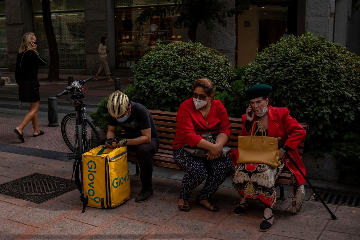 Pedestrians wearing face masks protection to prevent the spread of the coronavirus sit on a public bench in Madrid, Spain on Monday, Aug. 31, 2020. Spain, with nearly 440,000 infections of the new virus since February, has become western Europe's hardest-hit country by a new surging wave of fresh outbreaks.