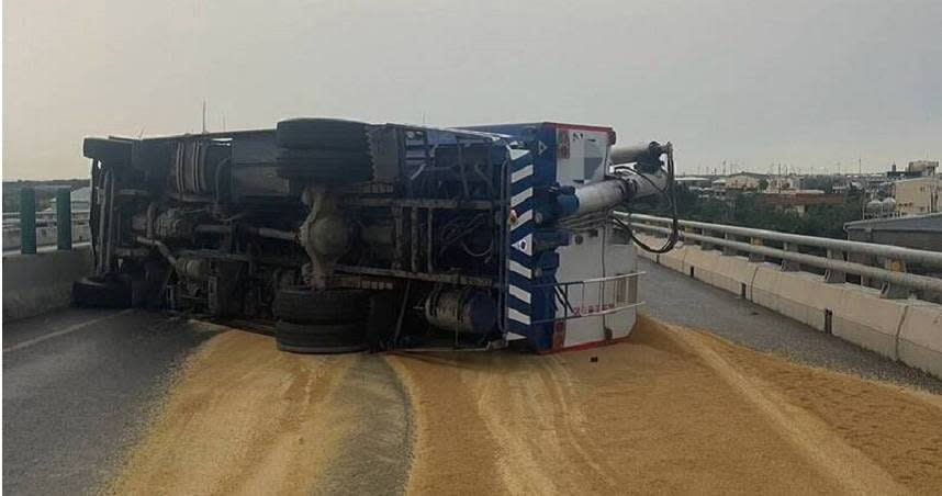 大貨車側翻飼料灑滿路，警方迅速處理。（圖／翻攝畫面）