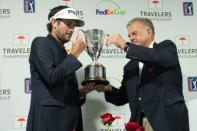 Jun 24, 2018; Cromwell, CT, USA; Bubba Watson is handed the championship trophy by Travelers Executive VP Andy Bessette after winning the Travelers Championship at TPC River Highlands. Mandatory Credit: Bill Streicher-USA TODAY Sports