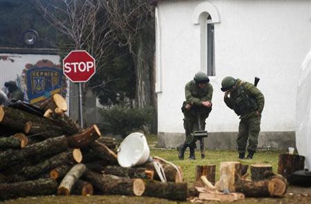 Armed men, believed to be Russian servicemen, stand guard outside an Ukrainian military base in the village of Perevalnoye near the Crimean city of Simferopol March 9, 2014. REUTERS/Thomas Peter