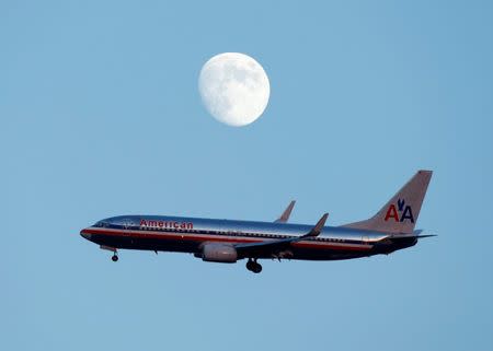 FILE PHOTO: An American Airlines passenger jet glides in under the moon as it lands at LaGuardia airport in New YorkNew York, August 28, 2012. REUTERS/Eduardo Munoz/File Photo