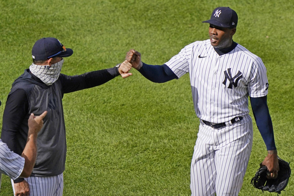 New York Yankees manager Aaron Boone, left, congratulates relief pitcher Aroldis Chapman after Chapman earned the save in the Yankees victory over the Baltimore Orioles in a baseball game, Sunday, Sept. 13, 2020, at Yankee Stadium in New York. (AP Photo/Kathy Willens)