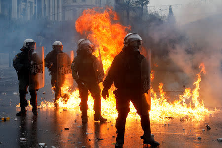 Police officers react next to a fire during a demonstration against the agreement reached by Greece and Macedonia to resolve a dispute over the former Yugoslav republic's name, in Athens, Greece, January 20, 2019. REUTERS/Alkis Konstantinidis