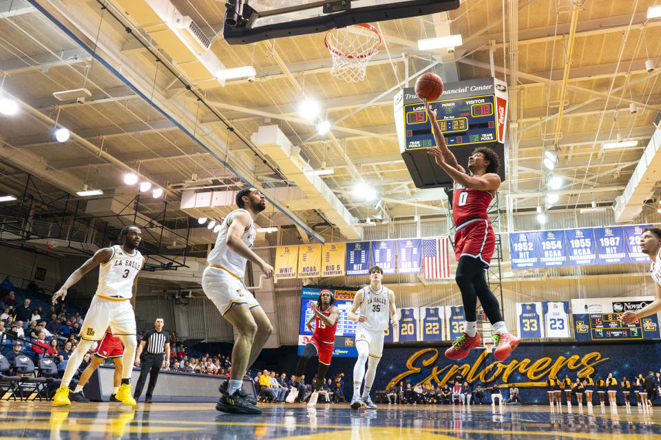 Dayton's Javon Bennett, right, shoots as La Salle's Daeshon Shepherd, second from left, looks on during the first half of an NCAA college basketball game Tuesday, Jan. 23, 2024, in Philadelphia. Dayton won 66-54. (AP Photo/Chris Szagola)